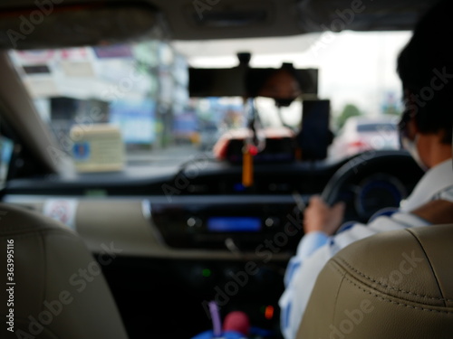 abstract blurred of back of taxi driver inside the taxi car.