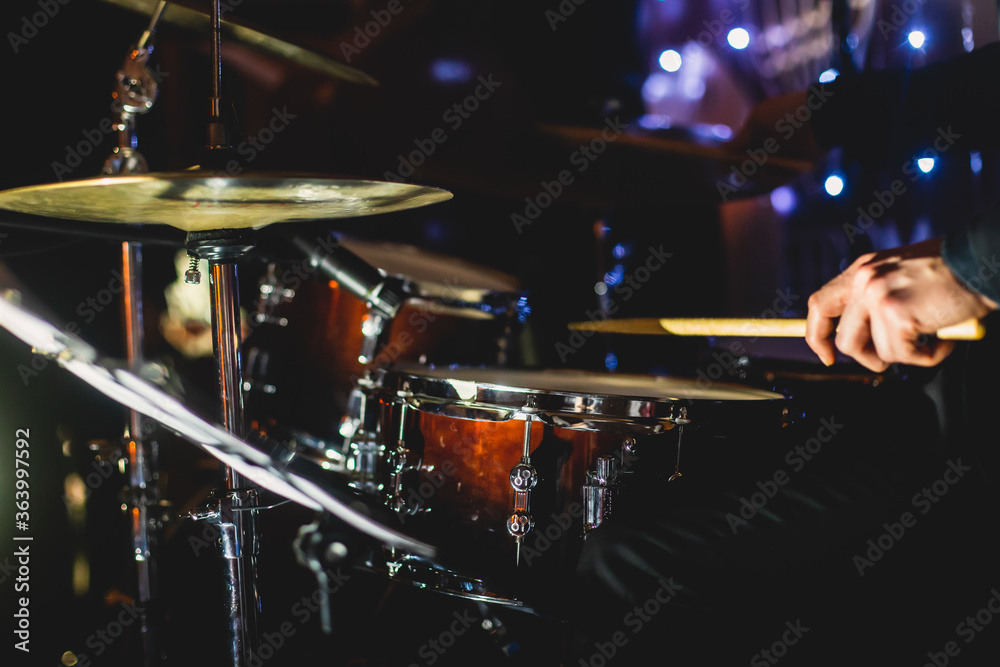 Fototapeta premium View of drum set kit on a stage during jazz rock show performance, with band performing in the background, drummer point of view