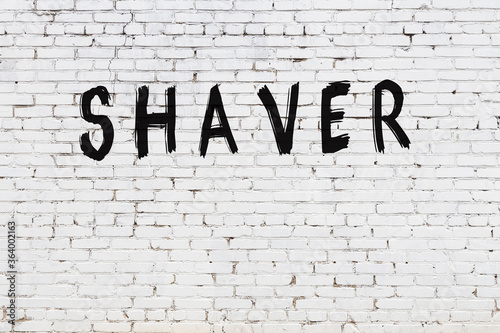 Inscription shaver painted on white brick wall