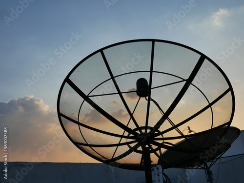 silhouette of satellite dish antennas at TV station.