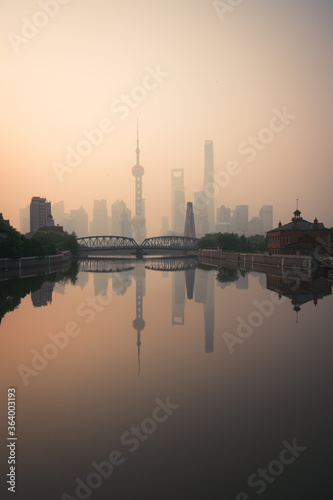 sunrise over the urban metropolis city in Asia with tall buildings and reflection in the river