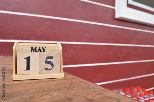 May 15, Number cube with wooden table beside the wall.