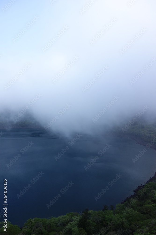 Onami-lake(old crater) covering fog in Kirishima mountain range in the early morning, Miyazaki, Japan Onami-lake(old crater) covering fog in Kirishima mountain range in the early morning, Miyazaki, Japan