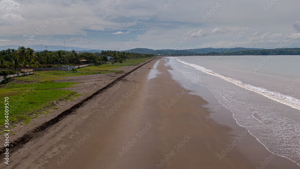 Beautiful aerial view of a empty beach due to the quarantine for Covid19, with a police car in Costa Rica 