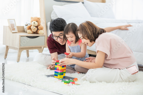 Tableau sur toile Little girl with learning disabilities Or the group of dow syndrome is learning about colorful wood toy with family teaching and encouraging beside