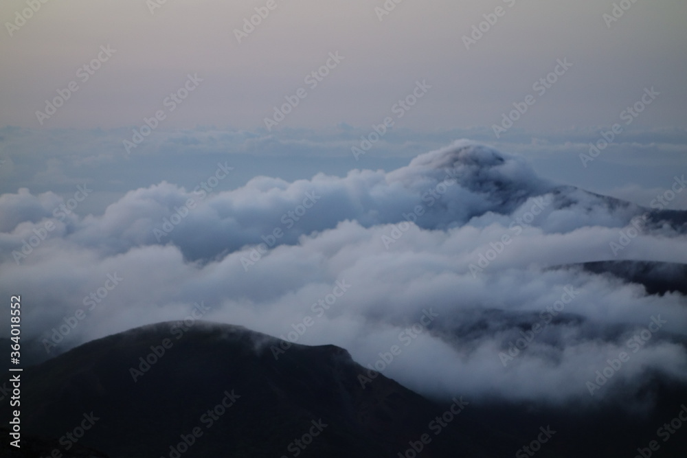 takachih-no-mine covering sea of clouds, one of the famous mountain where god came down and pierced the top by a big sword in Kirishima mountain range in the early morning, Miyazaki, Japan