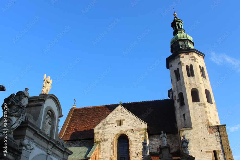 Fototapeta premium The Roof And Spires Of The Ancient Church Against The Backdrop Of An Almost Cloudless Blue Sky.