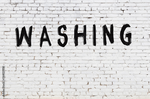 Foto White wall with black paint inscription washing on it