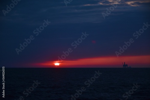 Autumn red sunset over the cold polar sea. Red clouds, illuminated by the cold sun, over the horizon. Photo from the side of the ship. © German