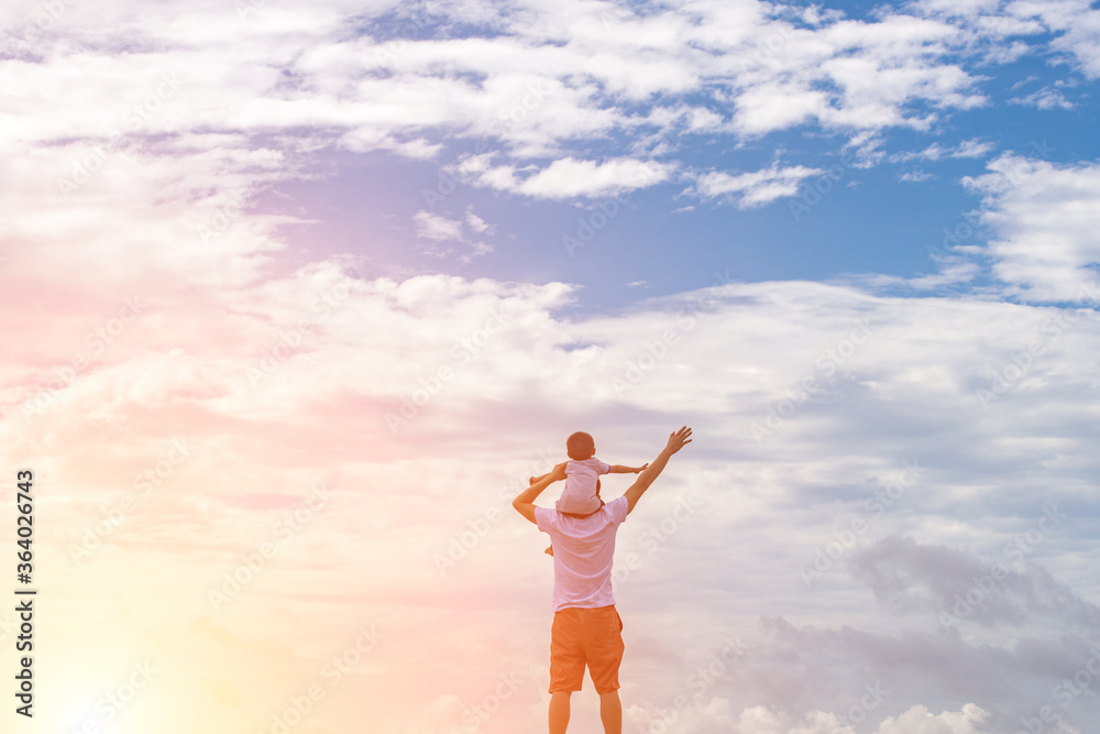 Father and children play together under the blue sky and white clouds