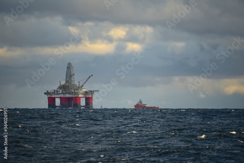 Wallpaper Mural Drilling platform at sea. Extraction of minerals on the shelf. A huge red platform rises above the water. The ship is nearby. Hydrocarbon energy.  Torontodigital.ca