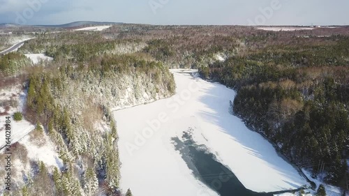 Aerial shot of forest with snow and frozen lake photo