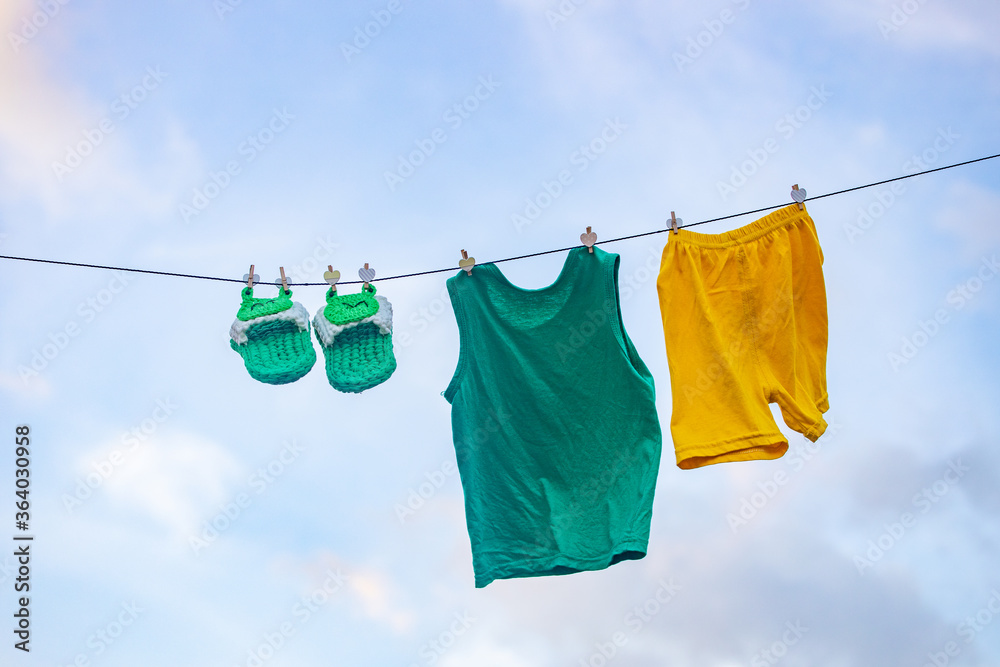 Φωτογραφία Homemade children's cloth slippers and clothes hung in the sun