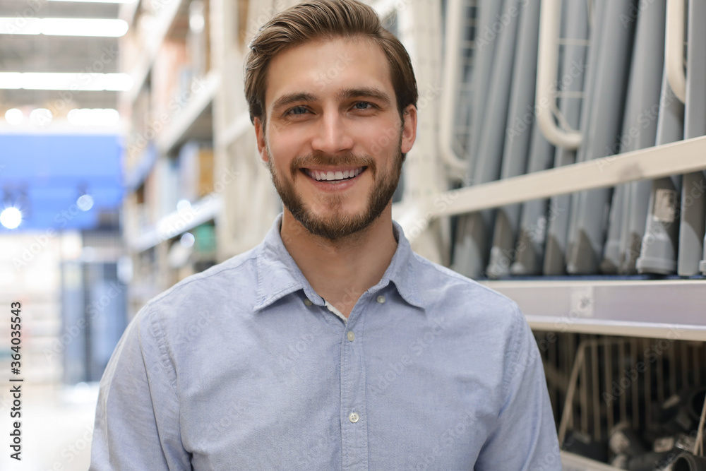 portrait of a smiling young warehouse worker working in a cash and carry wholesale store. portrait of a smiling young warehouse worker working in a cash and carry wholesale store.