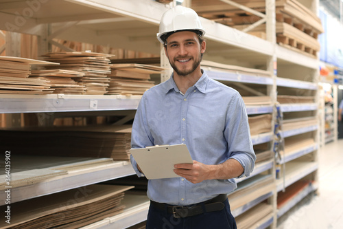 portrait of a smiling young warehouse worker working in a cash and carry wholesale store. photo