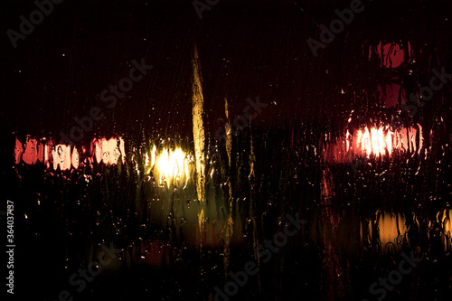 Blurry light on dark wet glass in the night