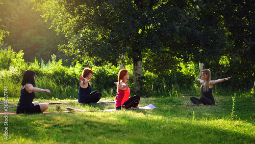 Fototapeta Naklejka Na Ścianę i Meble -  women in the Park with an instructor doing yoga