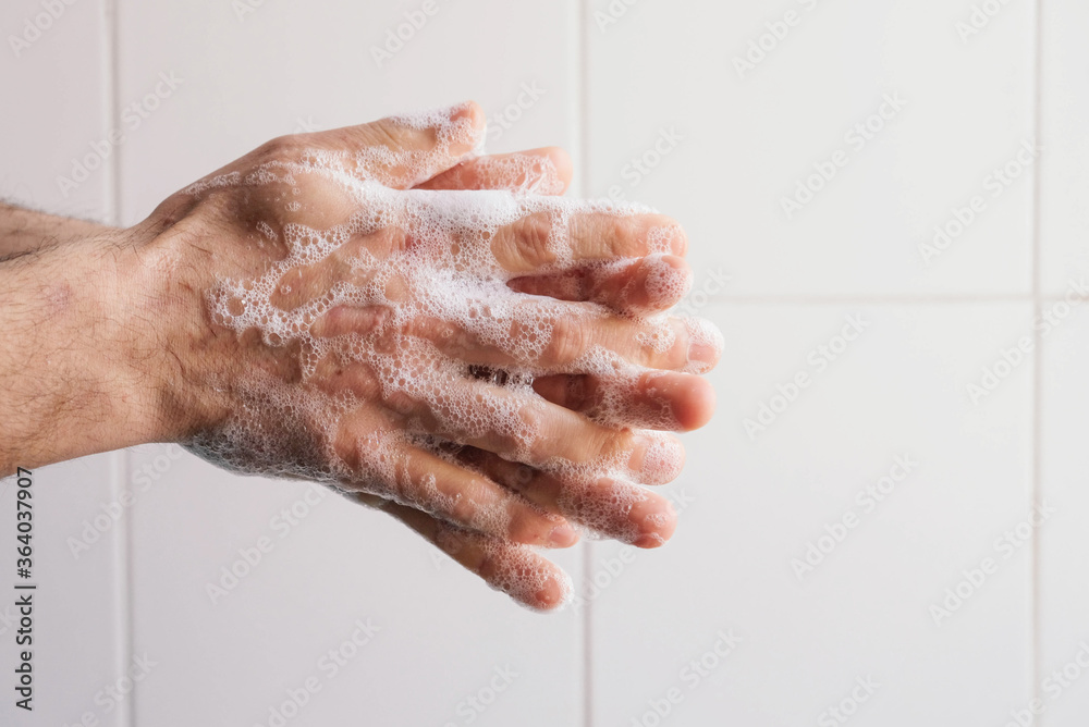 Fototapeta premium Man cleaning his hands using liquid disinfectant soap and water.