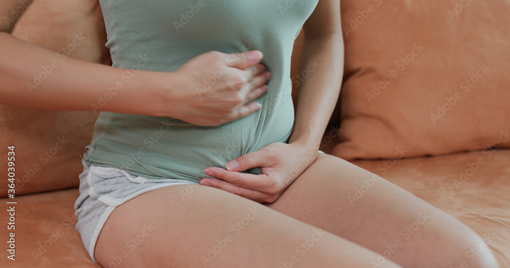 Woman suffer from stomach pain at home