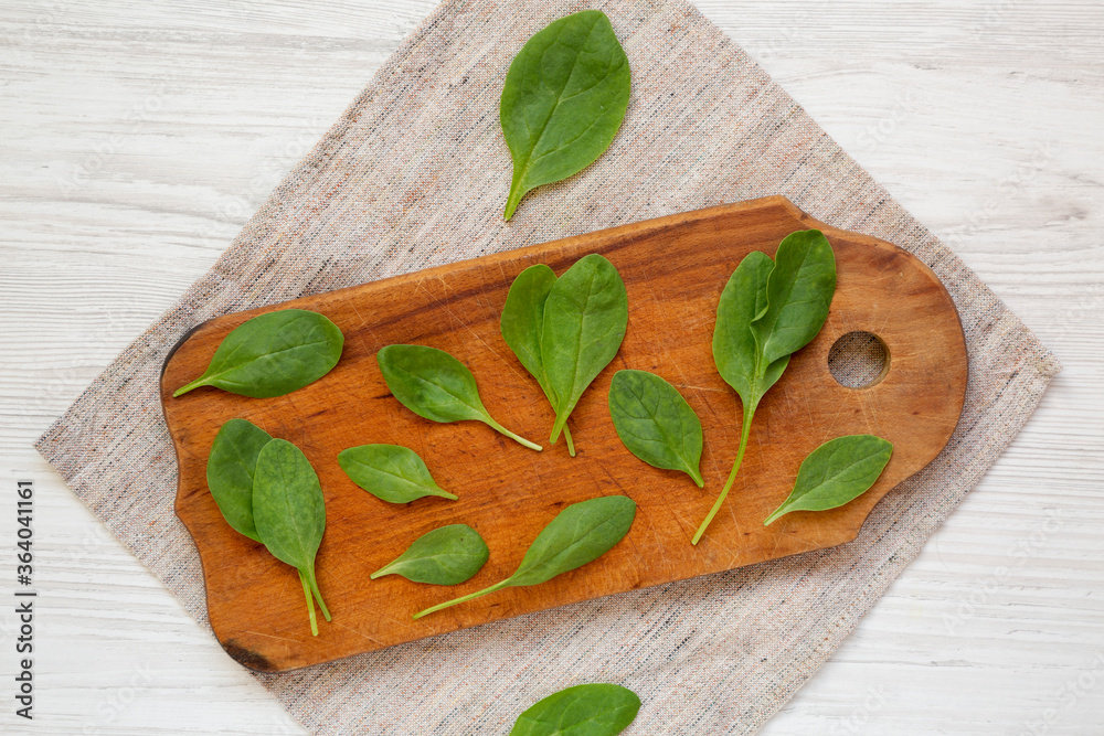 Fresh Baby Spinach on a rustic wooden board, top view. Overhead, from above, flat lay. Fresh Baby Spinach on a rustic wooden board, top view. Overhead, from above, flat lay.