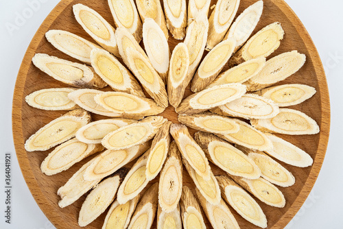 Astragalus membranaceus tablets on a plate on white background
