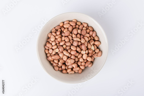Peanuts in bowl, isolated on white, top view