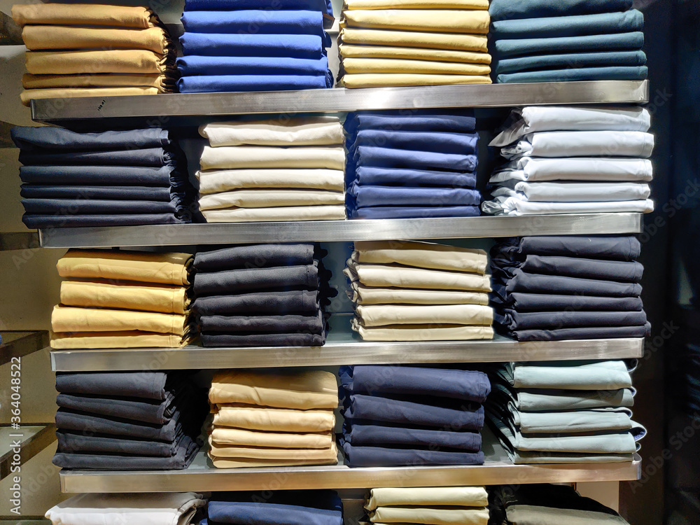 Large assortment of jeans trousers arranged on the shelf of a clothing store Large assortment of jeans trousers arranged on the shelf of a clothing store