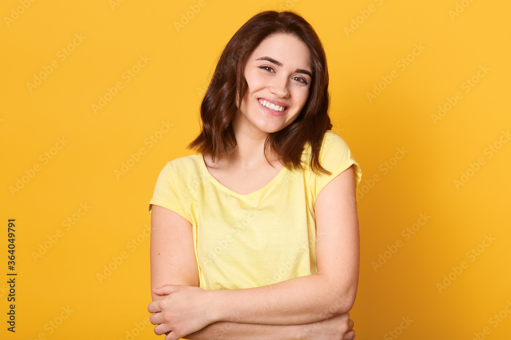 Yourself style stylish person optimClose up portrait of cute lovely charming adorable girl hugging herself isolated over yellow background, looking smiling at camera. Yourself style stylish person optimClose up portrait of cute lovely charming adorable girl hugging herself isolated over yellow background, looking smiling at camera.