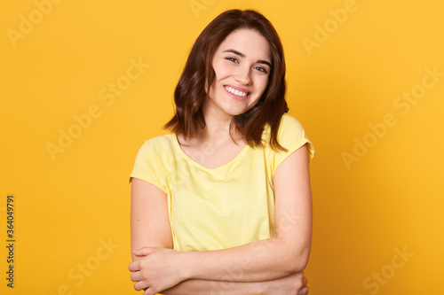 Yourself style stylish person optimClose up portrait of cute lovely charming adorable girl hugging herself isolated over yellow background, looking smiling at camera.