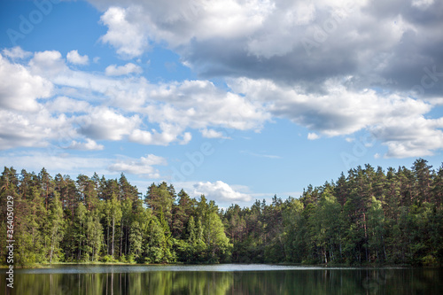 Fototapeta Naklejka Na Ścianę i Meble -  Cumulus clouds over a forest lake, Estonia
