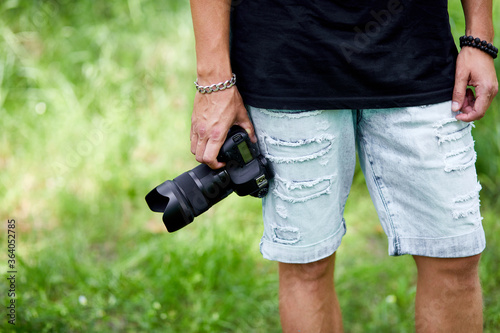 Man photographer with a photo camera in hand outdoor