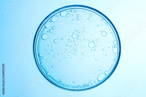 Photos some circle bubbles in a petri dish on blue background.