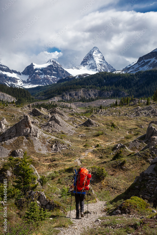 Adventure Backpacking in the Iconic Mt Assiniboine Provincial Park near Banff, Alberta, Canada. Girl Hiker with Canadian Mountain Landscape in Background.