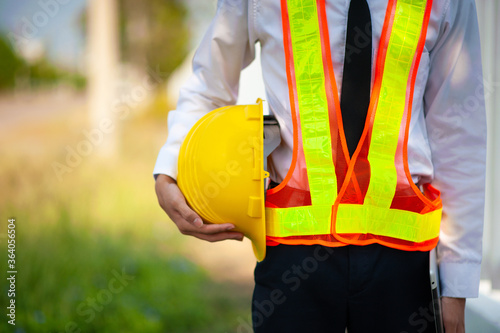 Close up project Engineer holding helmet hard hat construction building background