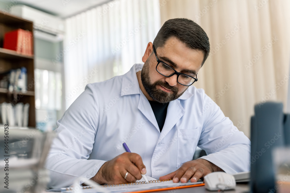 Obraz premium Serious doctor sitting at computer. Medical office. Doctor at work. Diagnosing.