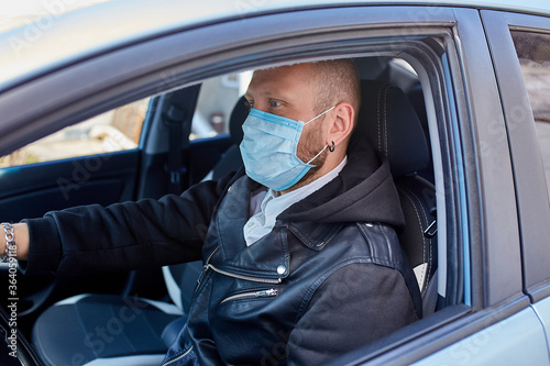 Man with protective mask adriving a car by Coronavirus pandemic quarantine © bondarillia