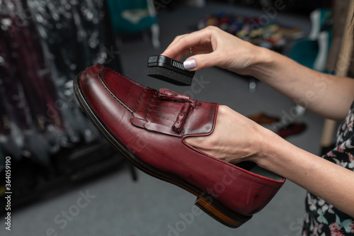 brown male shoes with accessories for care. fmale Hand cleaning a male boots, close-up.