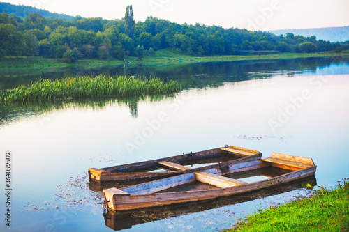 Fototapeta Naklejka Na Ścianę i Meble -  Old Sunken wooden boat . River shore with fishing boats 