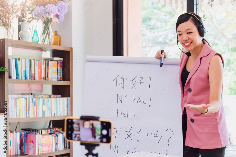 Asian woman teacher teaching remotely at home office with online