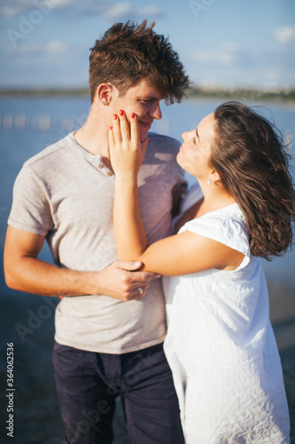 A couple in love on the beach. A man and a woman kiss. A couple in love walking on the beach. Date on the beach. Love.