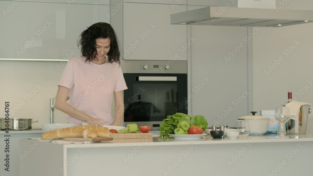 young pretty woman cooking cutting tomato in modern kitchen. Rbbro vegan housewife preparing organic vegetable green salad. concept vegetarian, ingredient, caucasian. young pretty woman cooking cutting tomato in modern kitchen. Rbbro vegan housewife preparing organic vegetable green salad. concept vegetarian, ingredient, caucasian.