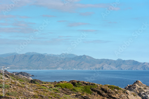 Sea landscape with Cap de Creus  natural park. Eastern point of Spain  Girona province  Catalonia. Famous tourist destination in Costa Brava. Sunny summer day with blue sky and clouds