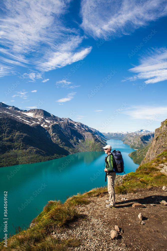 A hiker  enjoying the view of a mountain lake in Jotunheimen, Norway