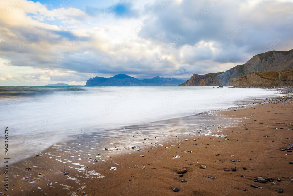 Sandy beach with mountains and blue sky