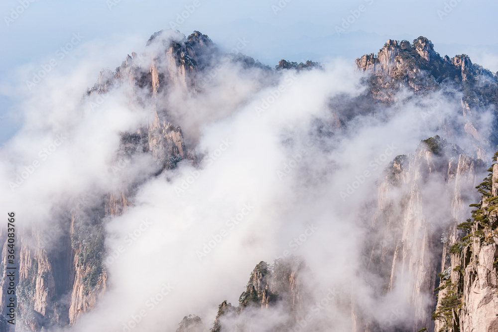 Clouds by the mountain peaks of Huangshan National park at sunrise time.
