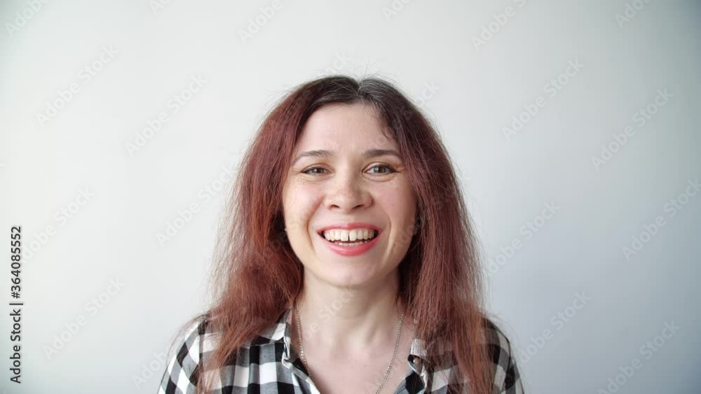 Young happy woman looks in the mirror and plucks a grey hair from her head. Concept photo of young woman getting old Young happy woman looks in the mirror and plucks a grey hair from her head. Concept photo of young woman getting old