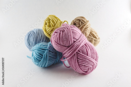 Multi-colored skeins of woolen threads of light background. Different sizes. Set of colorful rolls of yarn. Can be used for online stores.