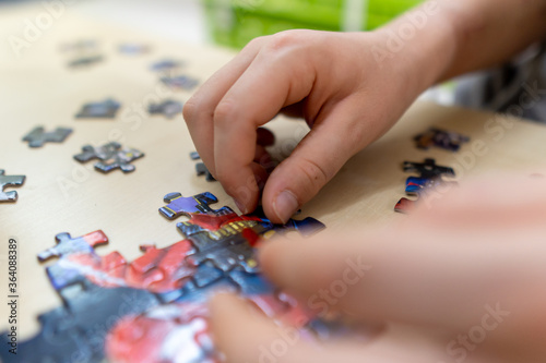 Creating and problem solving is a key skill in today's world. Kid putting colourful puzzle together close up shot. Selective Focus.