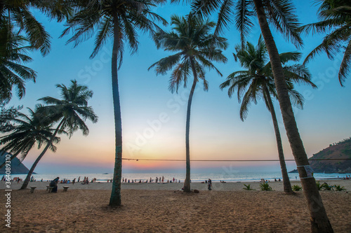 Amazing dusk vie on sunset with palms and beach and water of Indian Ocean