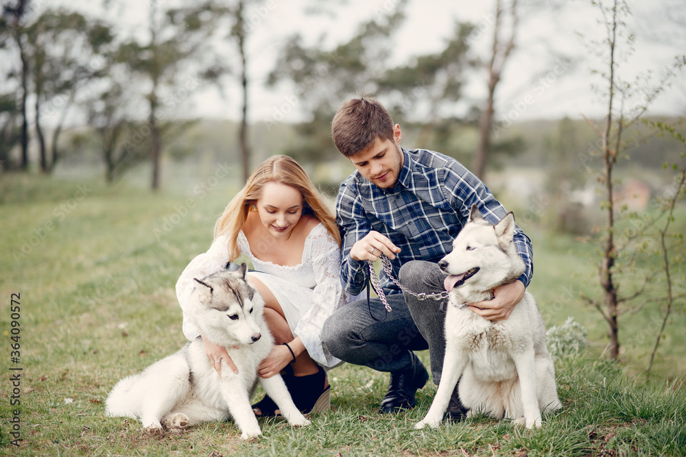 Couple in a forest. Pair with cute dogs. Lady in a white dress Couple in a forest. Pair with cute dogs. Lady in a white dress
